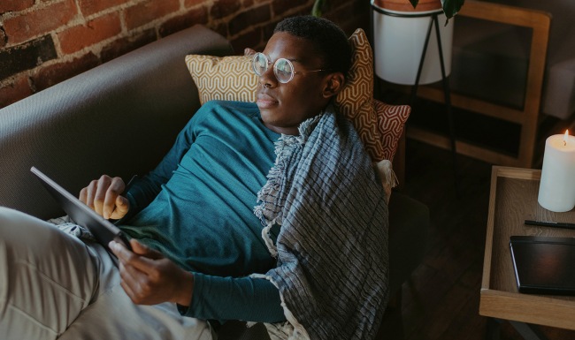 A new standard of living lifestyle image of a man reading a smart device in a bright room
